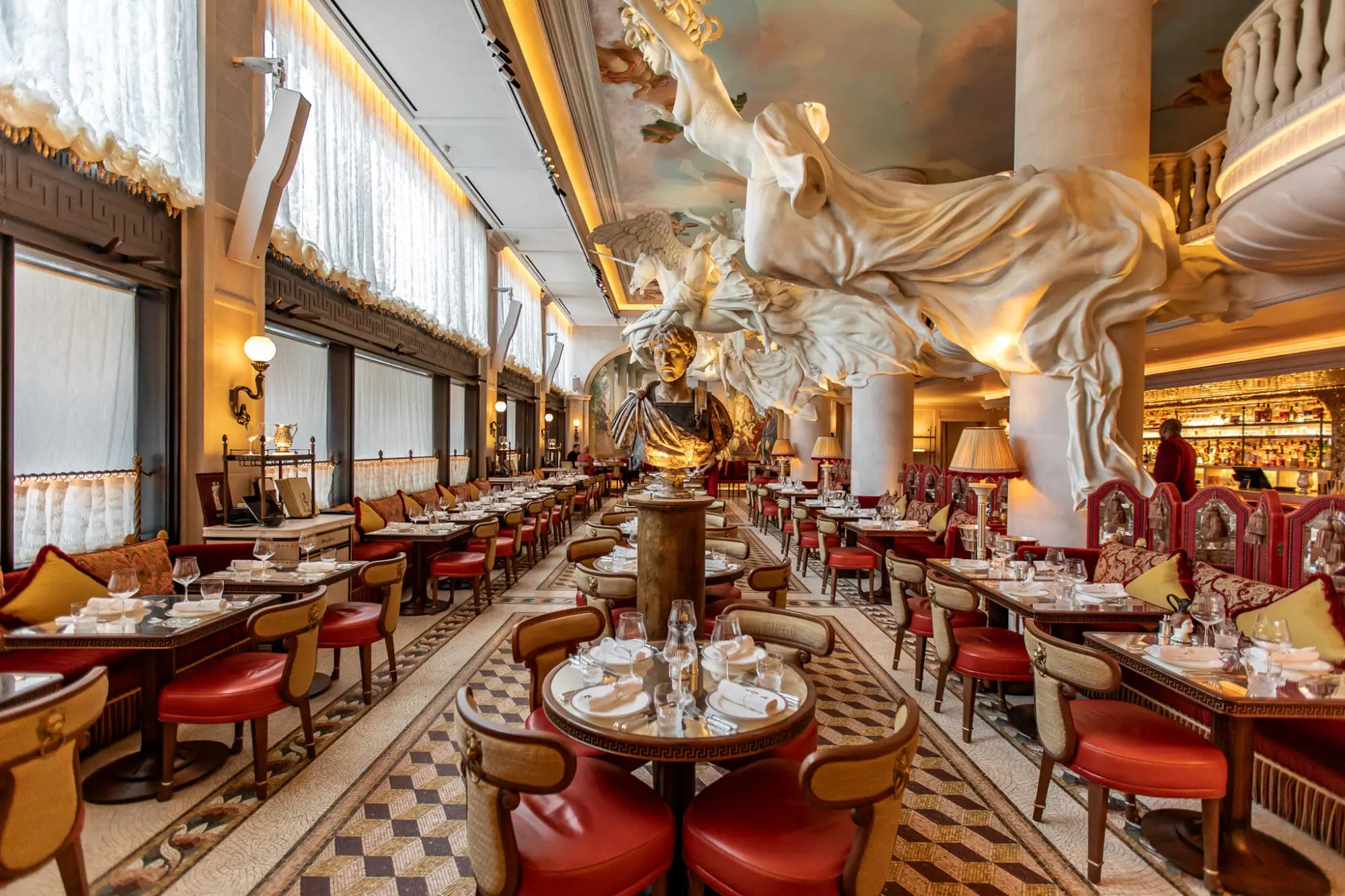Bacchanalia Restaurant in London. Large, impending sculptures and Roman statues loom large over the dining room.