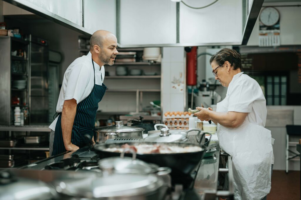 Two chefs talking in the kitchen