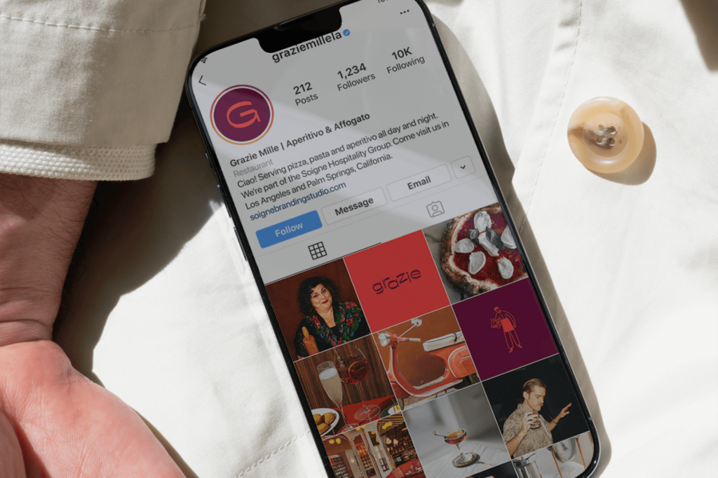 A chef holding an iphone with a restaurant instagram profile