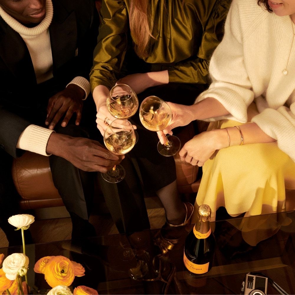 Glamorous guests at a cocktail bar sitting and drinking champagne