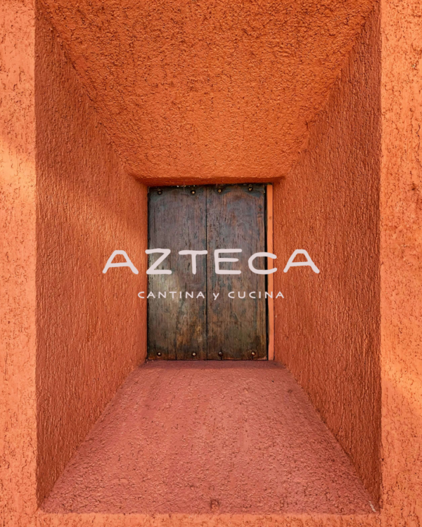 A mockup of the Azteca logo over a wooden door and terra cotta stucco background.