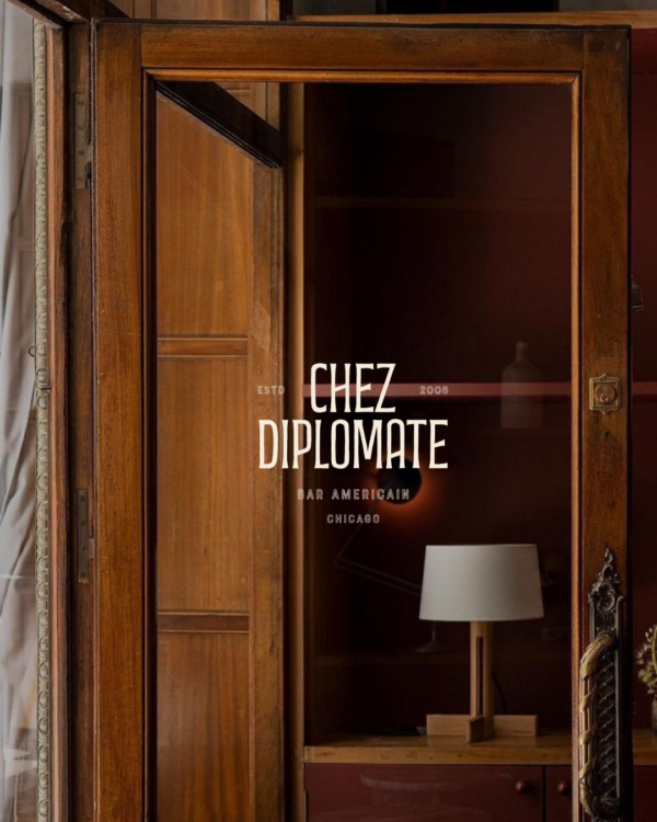 From inside a restaurant, looking at a door frame with a "Chez Diplomate" window decal.